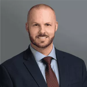 Headshot of Dr. Norman's in professional wear with a grey background.