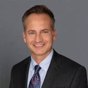 Headshot of Dr. Steven Maier in professional wear with a grey background.
