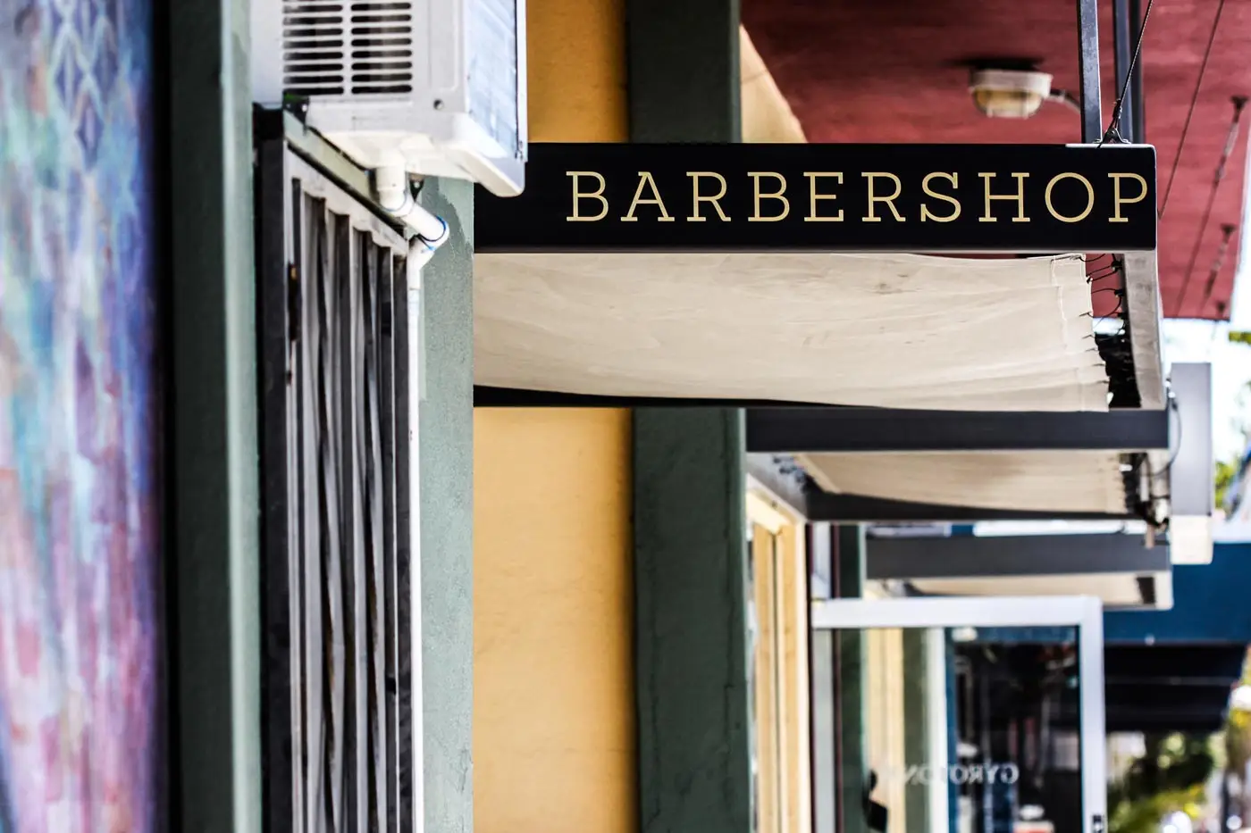 Stylish Montreux street featuring vibrant facades near luxury GuestLee apartments, with a BARBERSHOP sign above the entrance. | GuestLee luxury rental Switzerland