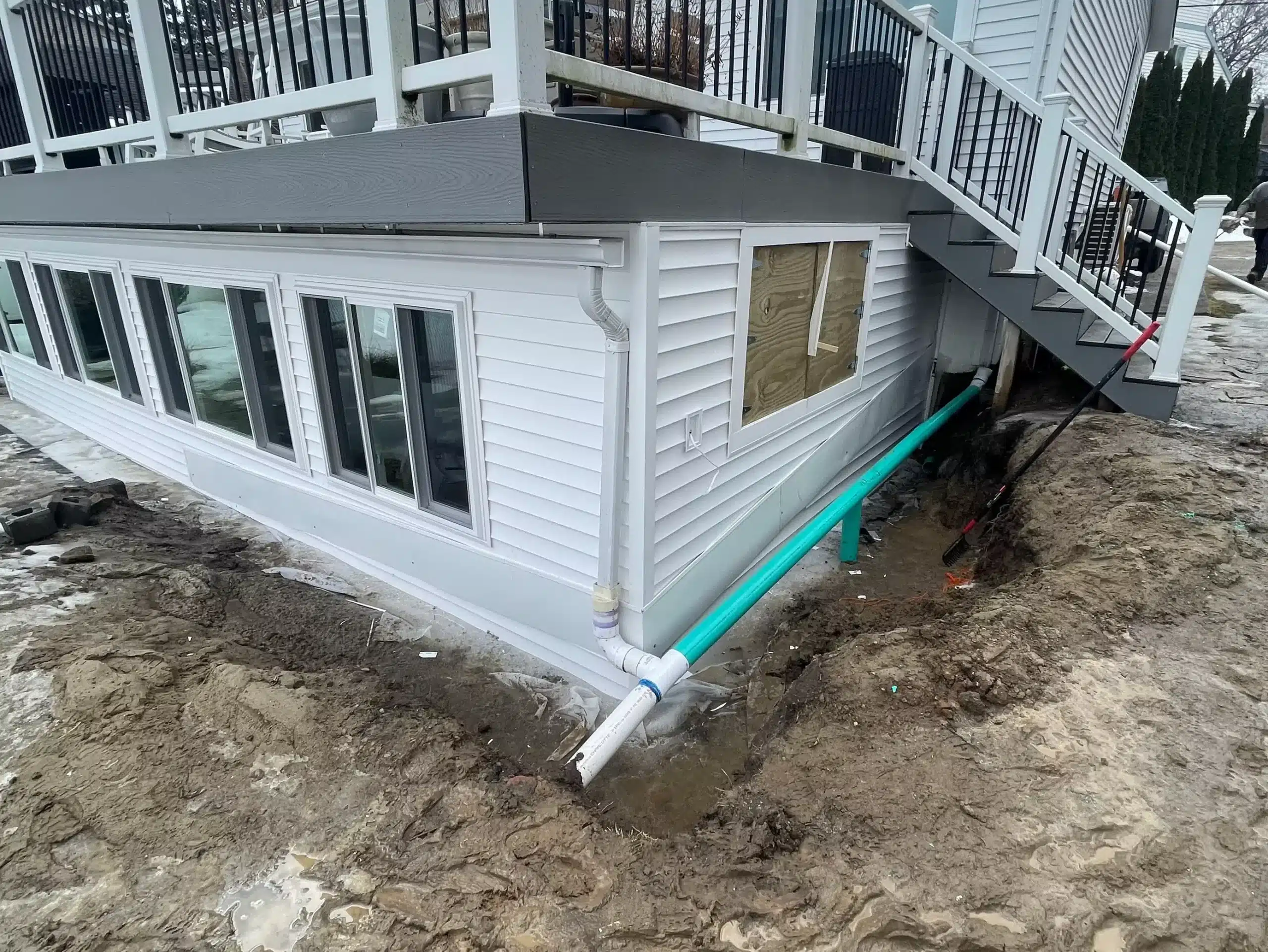A house with a staircase and a drain pipe, ideal for drainage and waterproofing services Mid Michigan homeowners may need. Kenneth Bros