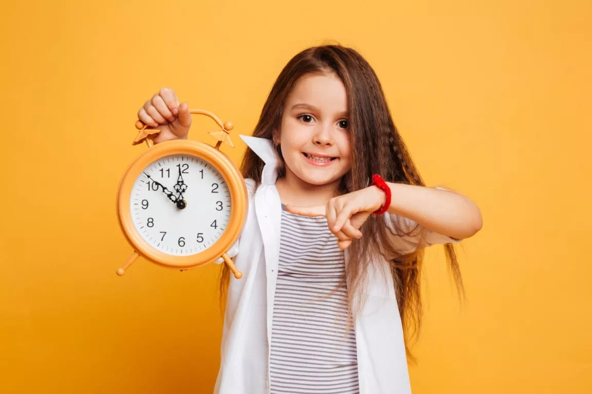 petite fille qui tient une horloge