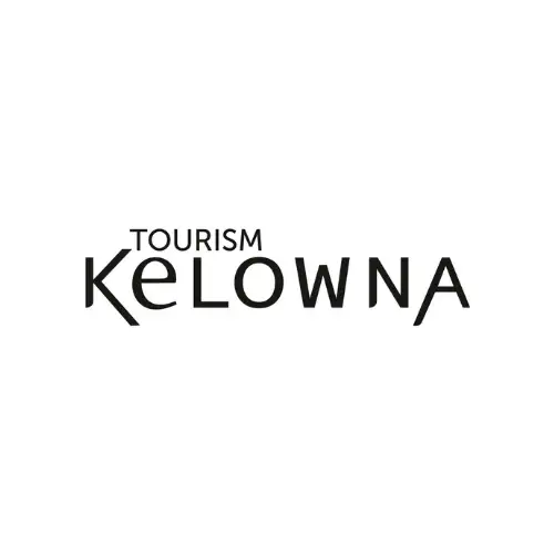 Black "Tourism Kelowna" logo on a white background, with "Kelowna" in a stylized font and "Tourism" in smaller letters above the "K," perfect for those interested in vacation rental management in Big White.