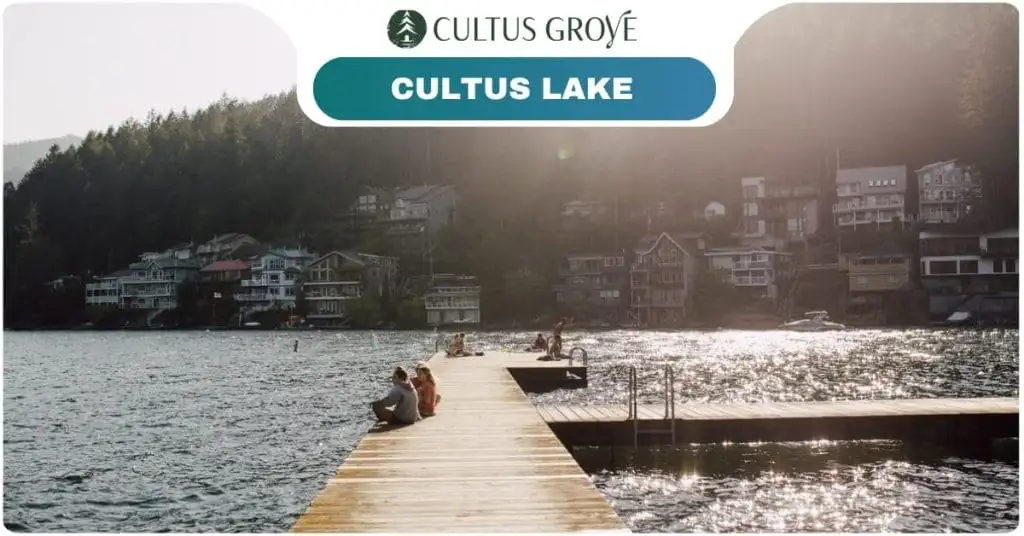 A wooden dock extends into Cultus Grove’s shimmering lake, with people relaxing on it; houses and trees line the sunny opposite shore. Text reads "Cultus Grove" and "Cultus Lake.