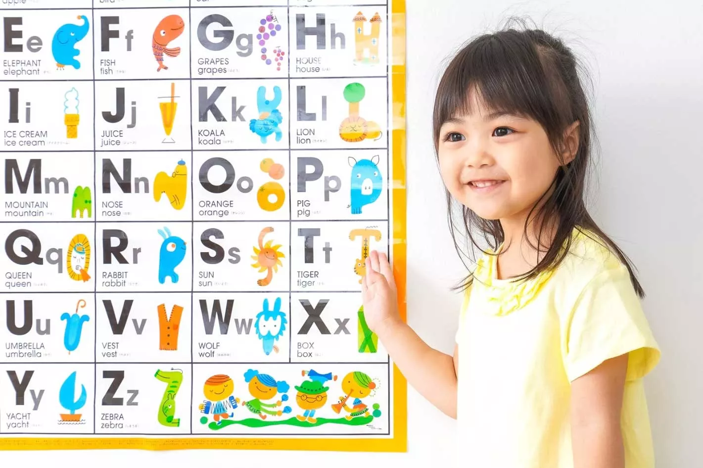 A girl in front of a Visual Support for her ABA therapy clinic.