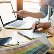 2 people working with a laptop and color samples