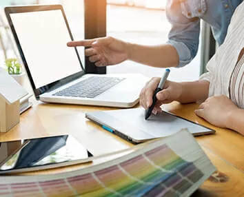 2 people working with a laptop and color samples