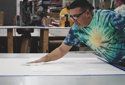 print operator cleaning a material before printing on a flatbed machine careers in commercial printing