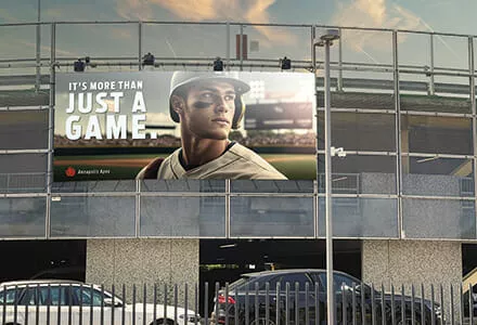 Baseball billboard on the side of a stadium of a baseball player and a phrase that says 