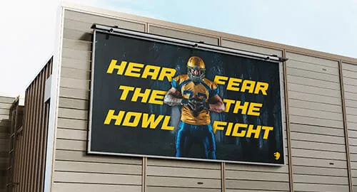 Large building signage featuring a college football motto and player.