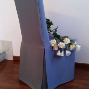 Coprisedia per ristorante modello Minimal in tessuto grigio azzurro, caratterizzato da linee tese, pulite e uno spacco laterale a soffietto per una vestibilitร sartoriale impeccabile.