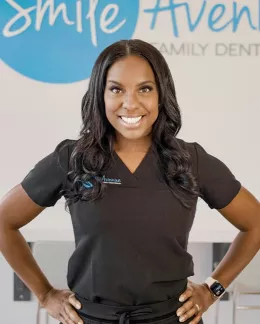 Smiling dentist in black uniform at Smile Avenue Family Dentistry in Cypress, TX.