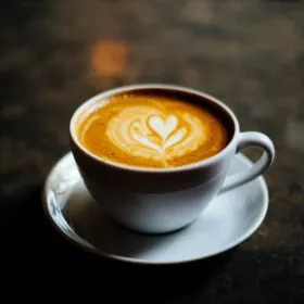 Best coffee beans 2025: The image shows a creamy cup of coffee on a table.