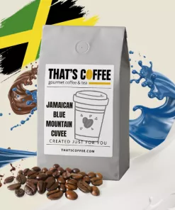 A bag of "That's Coffee" Jamaican Blue Mountain Cuvee sits among Jamaican coffee beans, with splashes of milk and coffee, and a Jamaican flag in the background.