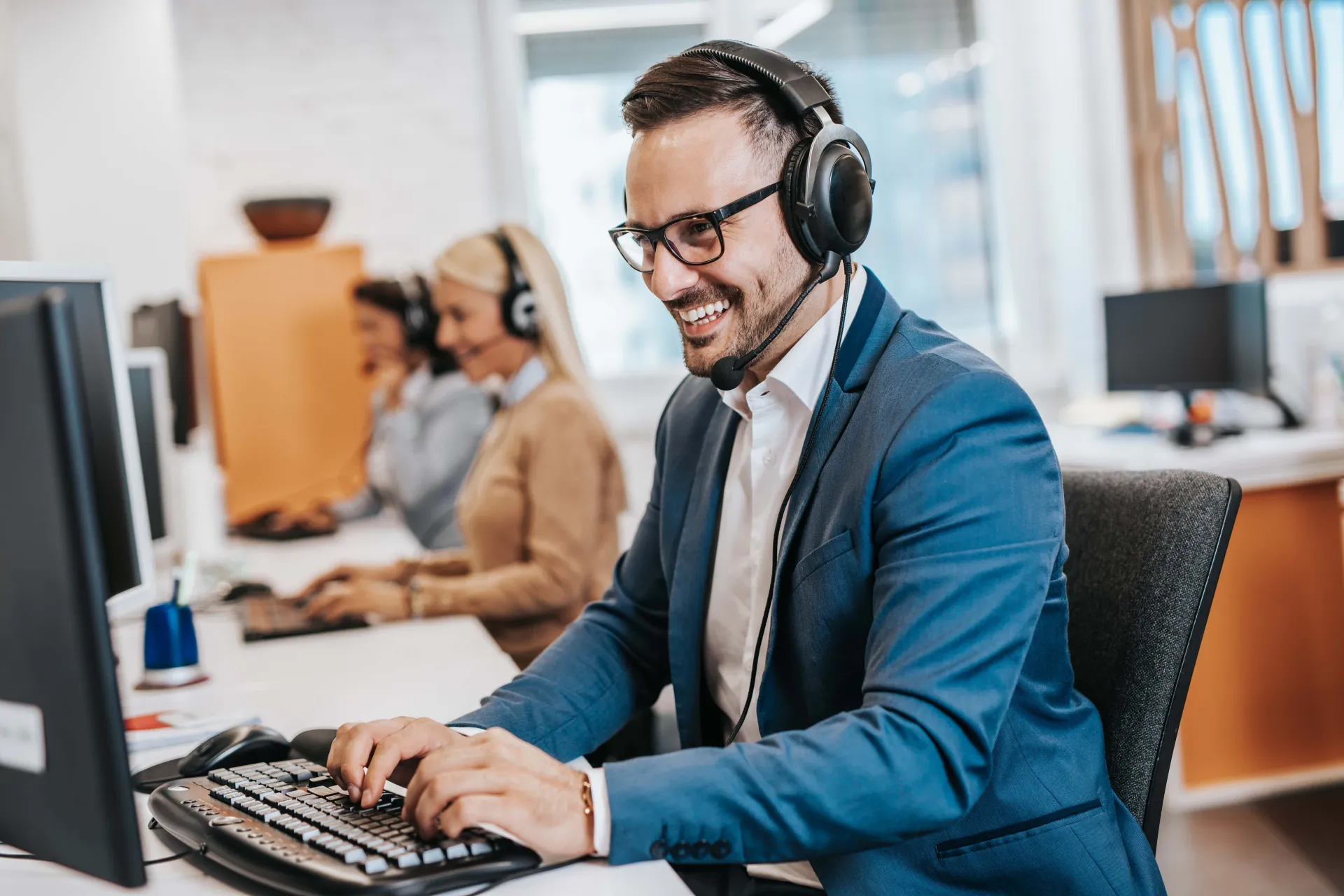 Handsome male customer service agent working in call center office as a telemarketer. Handsome male customer service agent working in call center office as a sales development specialist