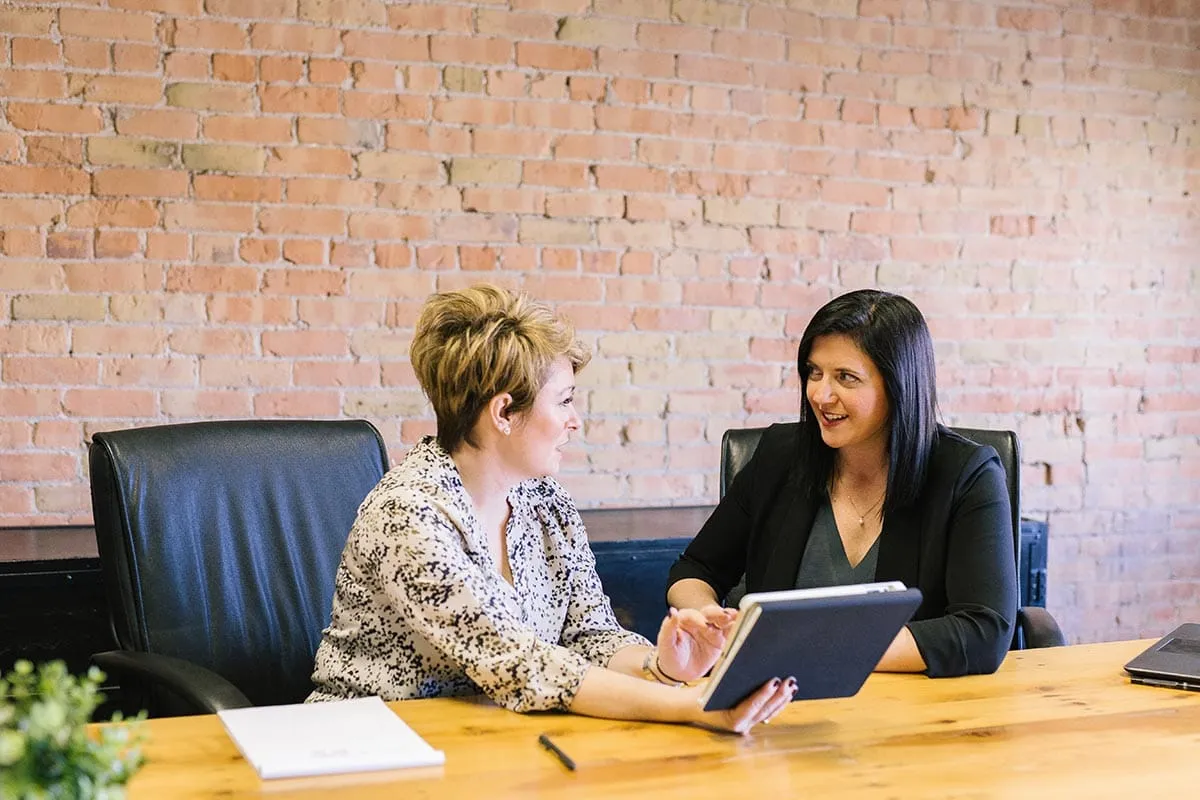 building-relationships Two women talking at a conference table