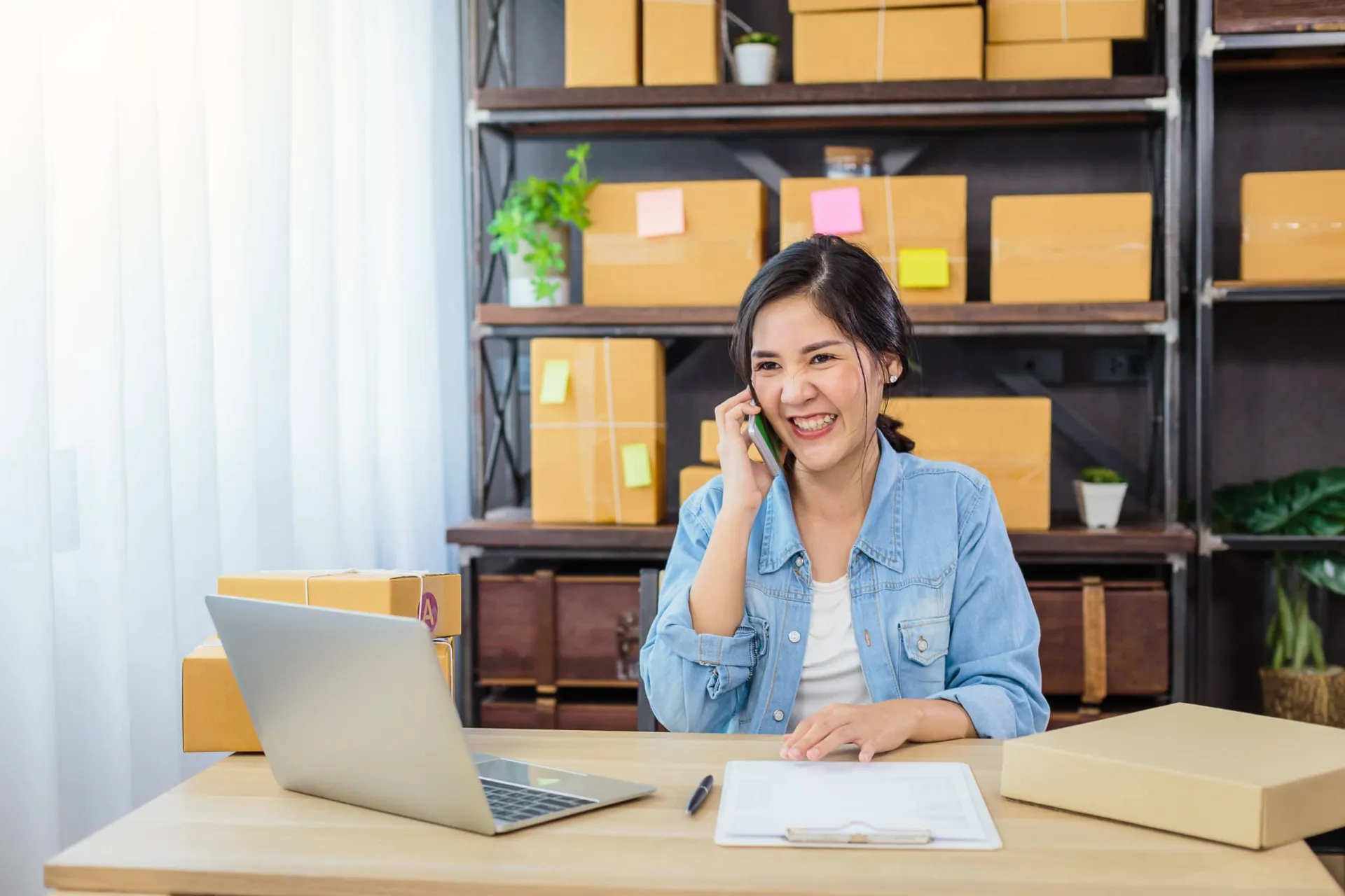 Productivity professional managing B2B sales funnel B2B sales funnel management: woman on phone with laptop and checklist.
