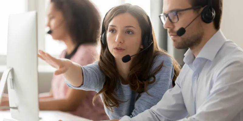 Customer support representatives using headsets in a call center environment.
