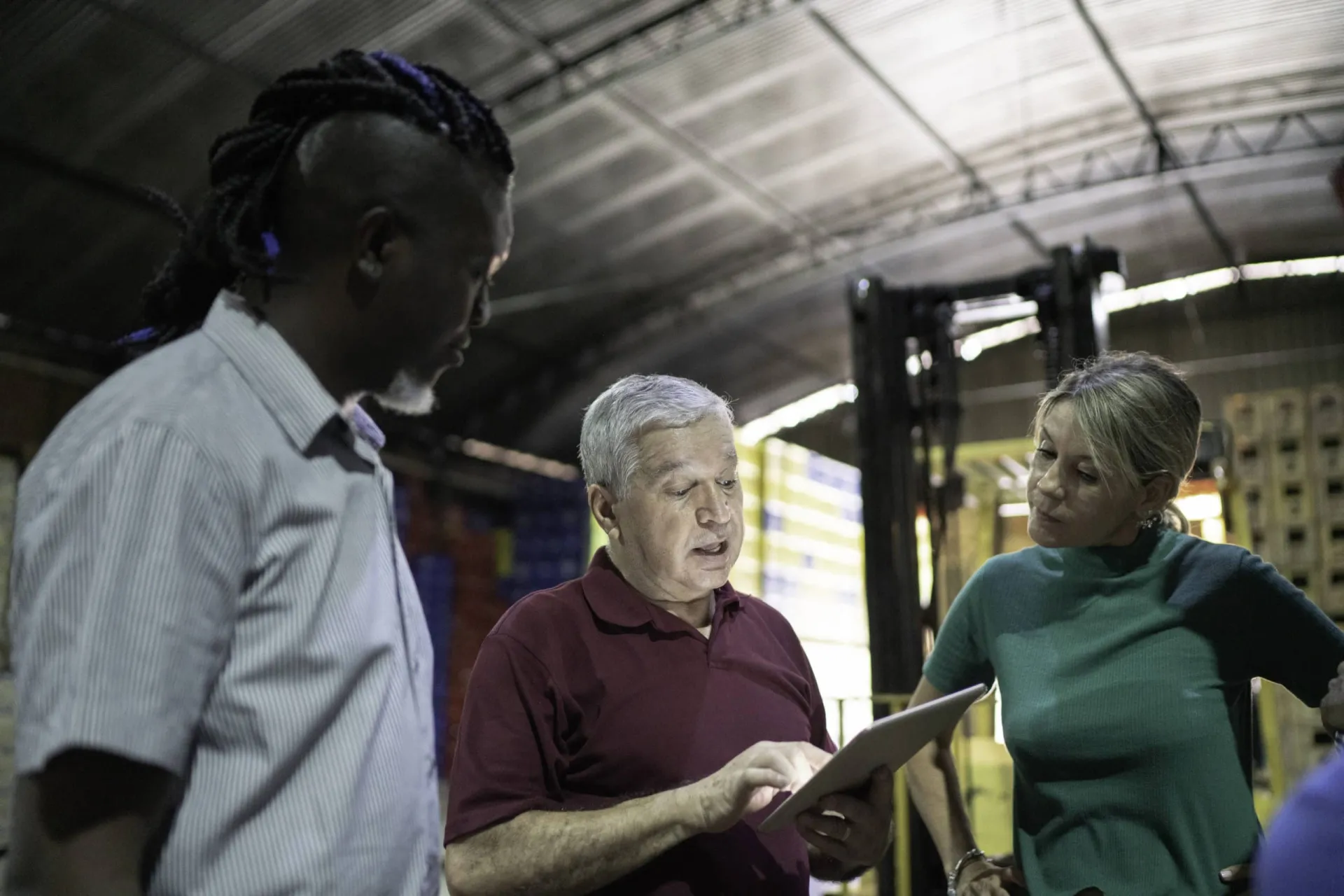Manufacturing team discussing outbound calling strategies Manufacturing team discussing outbound calling benefits in a warehouse setting.