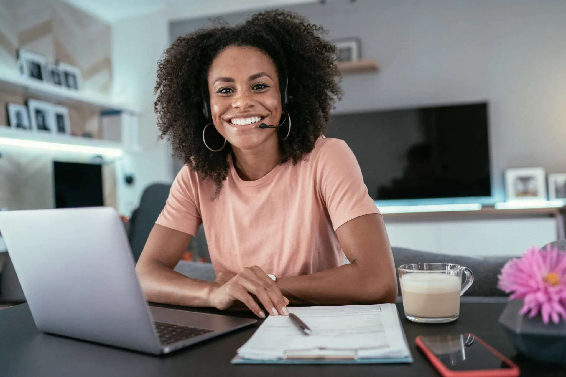 Workday of a Business Development Rep Smiling woman working at home with laptop and notepad, representing a business development professio.