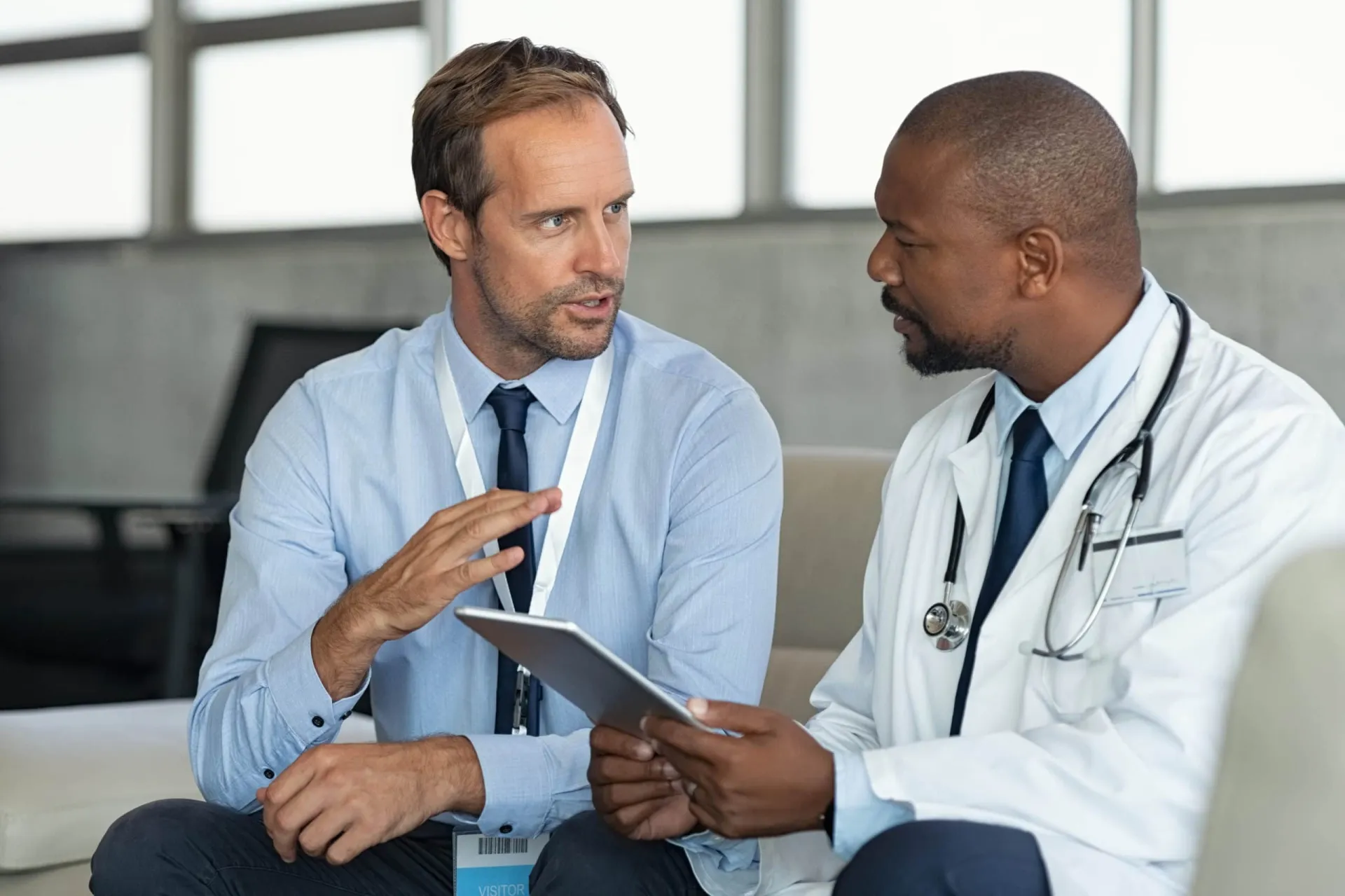 Patient and doctor discussing healthcare appointment details in a medical office. Closing a lab sales deal