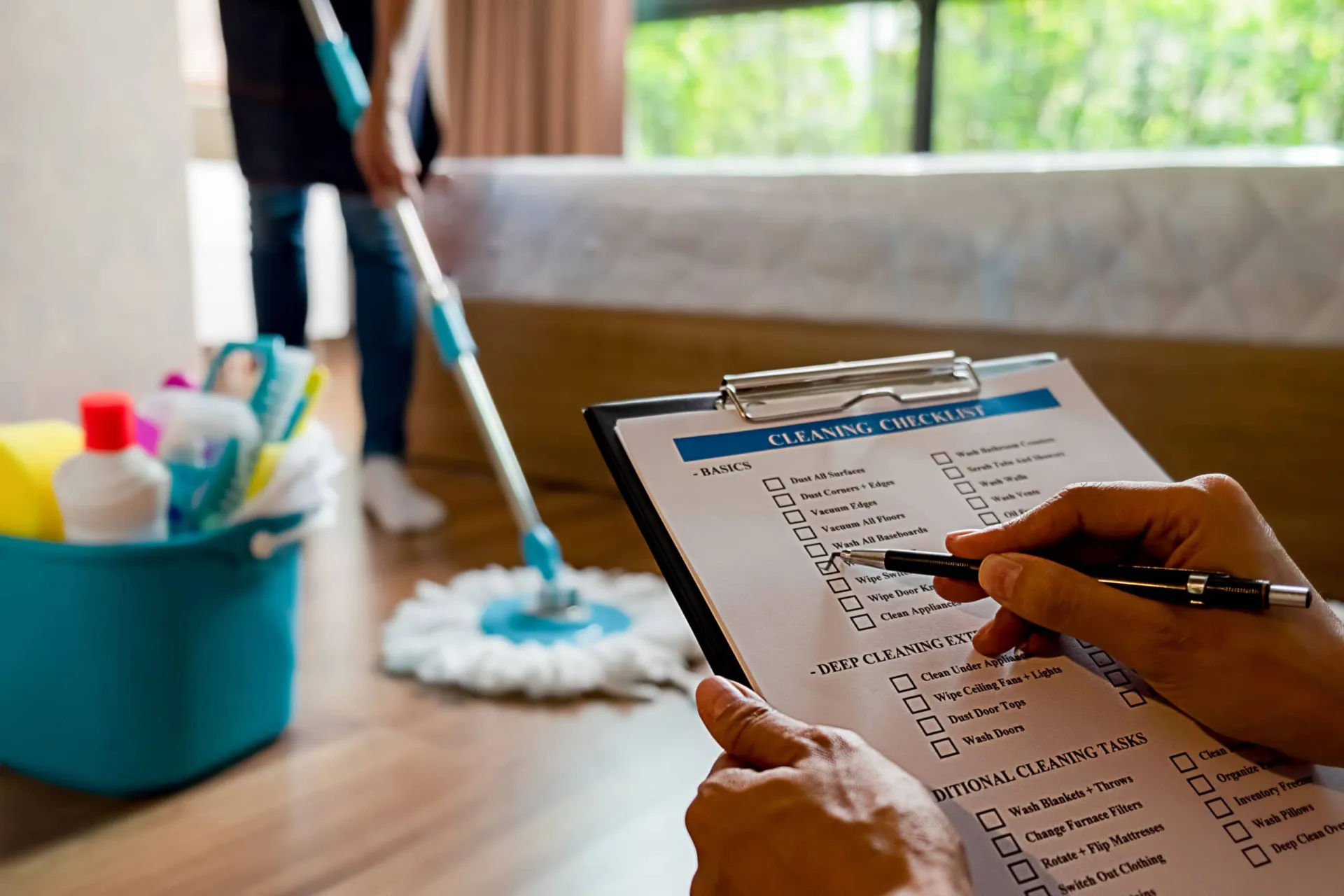 Cleaning Checklist for Spring Sales Prospect Lists Person checking off a cleaning checklist while preparing sales prospect lists in a home setting.