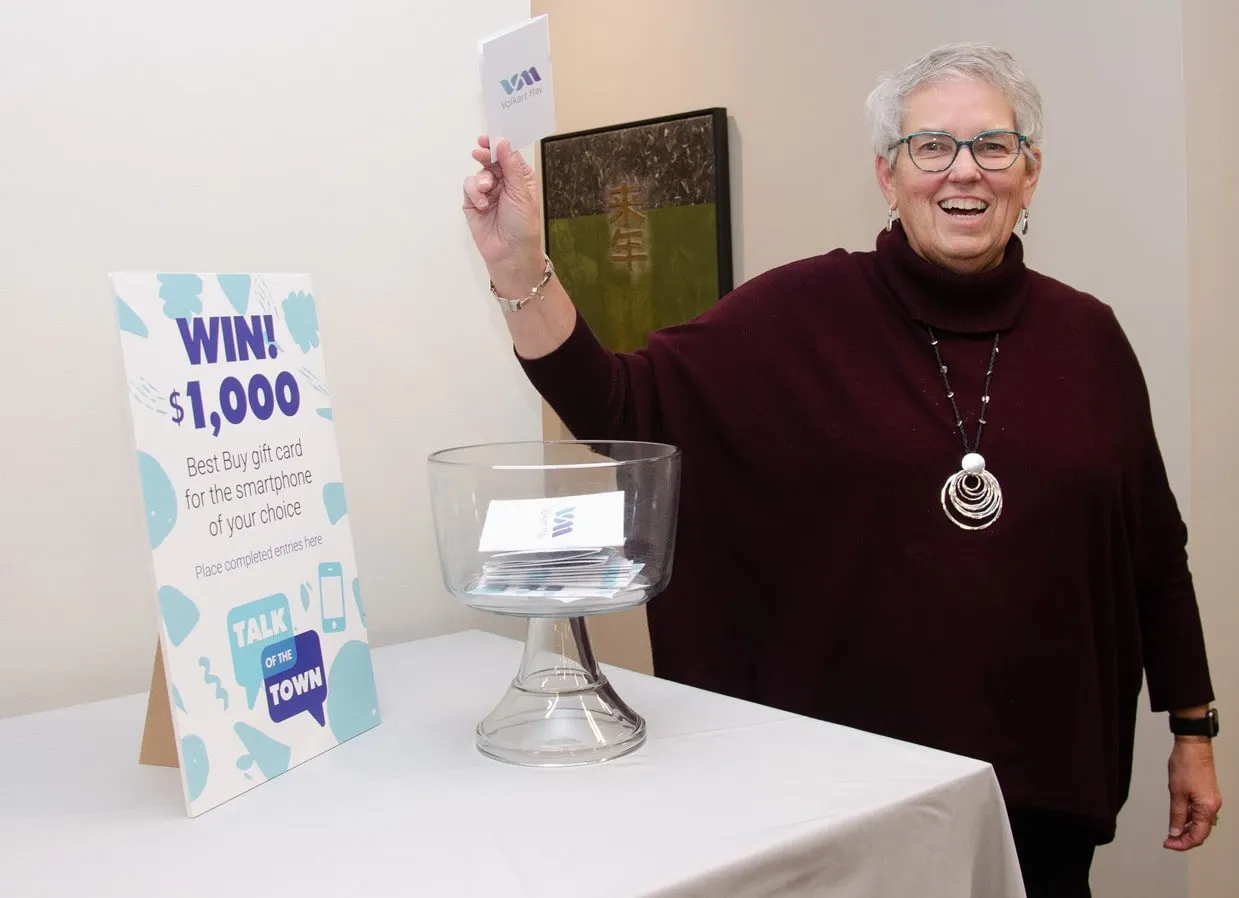 Volkart May Call Center Tour Woman celebrating at call center with prize draw sign.