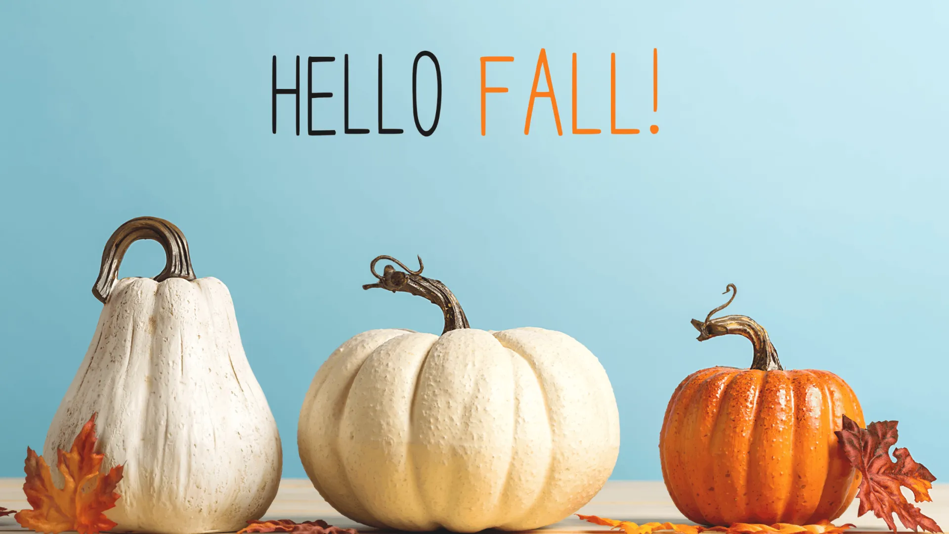 Autumn Pumpkins and Fall Decor Three decorative pumpkins with fall leaves and text ‘Hello Fall’ on a blue background