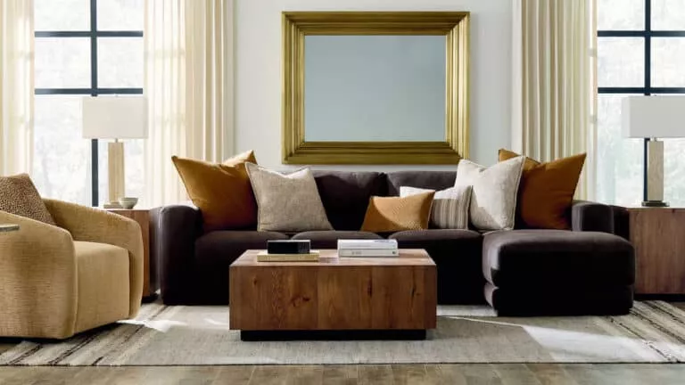 A living room with Bassett furniture. Includes a dark brown couch, neutral arm chair, and and a dark wood coffee table
