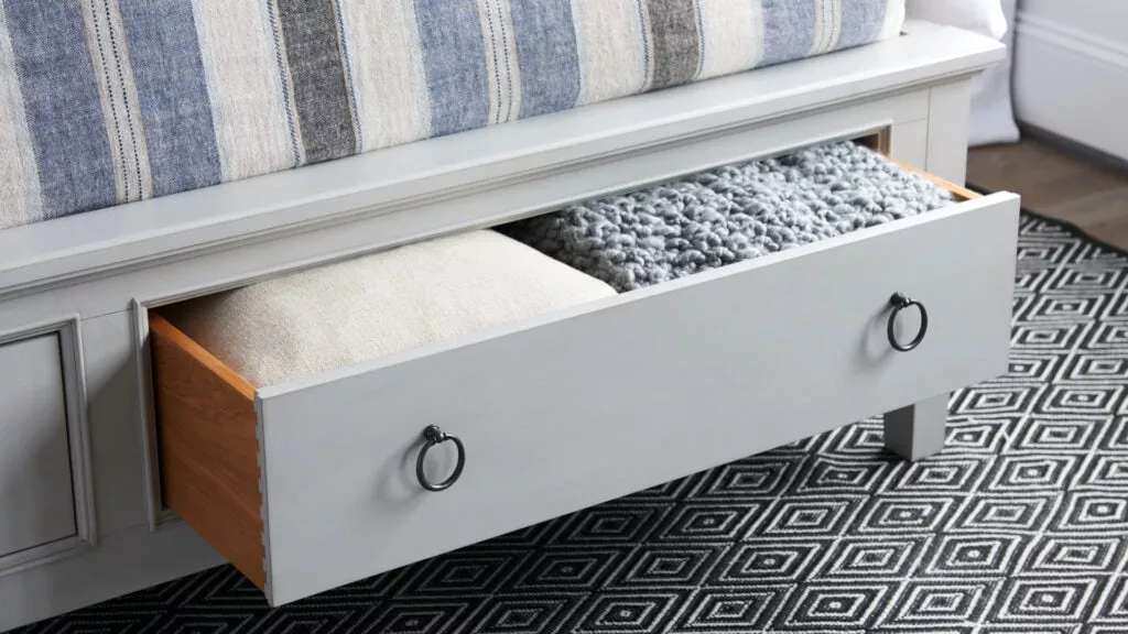 An open storage drawer on the bottom of a bed frame. The product is from Universal Furniture.