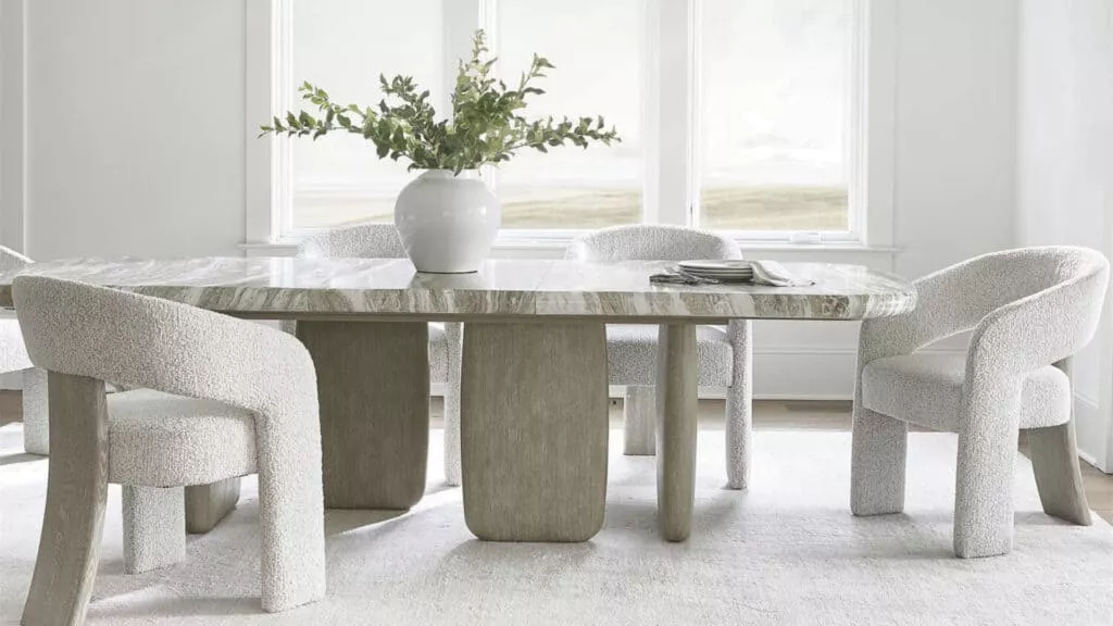 A dining room scene with an abstract marble dining table and textured dining chairs.