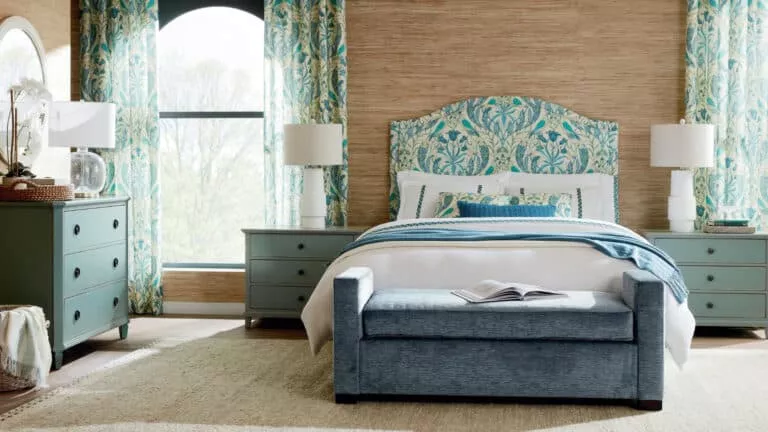 A bedroom featuring a bed, two nightstands, a dresser, and a seating area. Products are from Universal Furniture.
