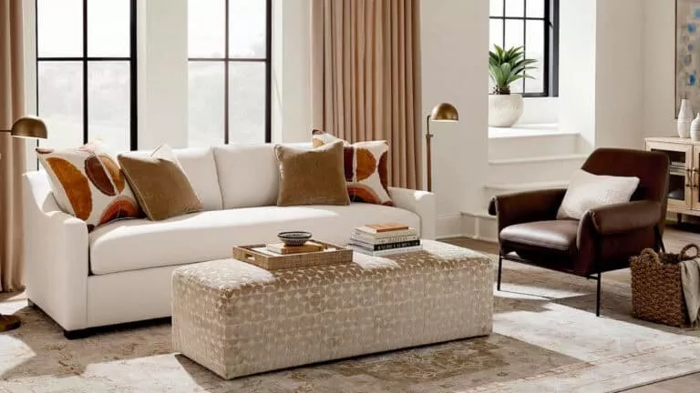Living room with a white couch, brown leather arm chair, and coffee table in the center
