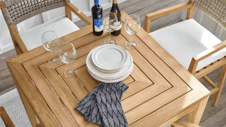 Wood table set with plates, wine bottles, wine glasses, and decorative napkins