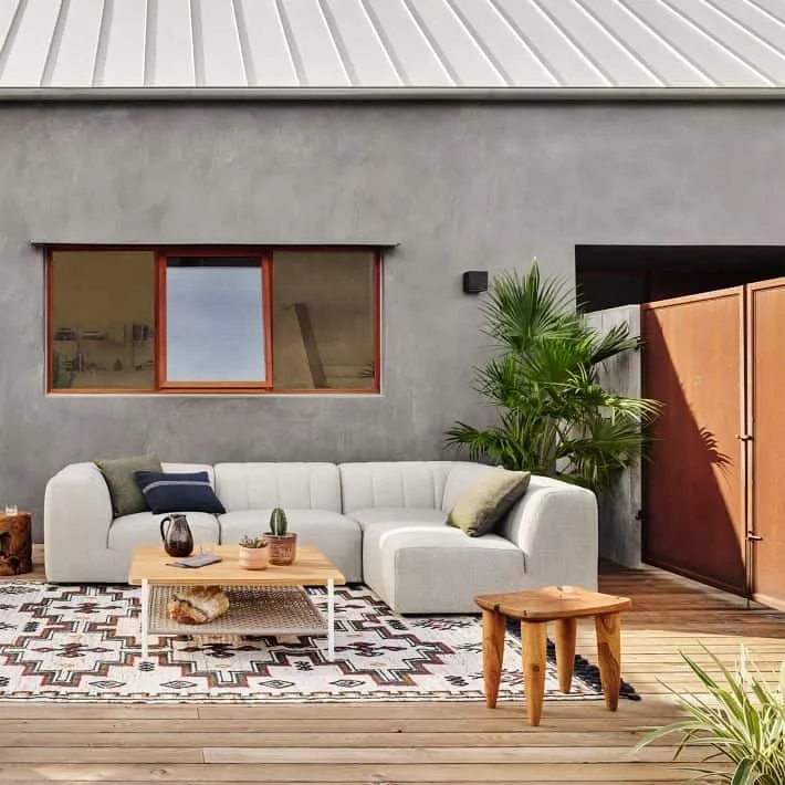 An outdoor patio with a couch and tables