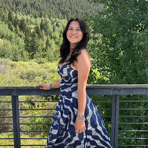 Kim-Miller_Silvia_Silver A young woman in a blue and white dress poses against a forest landscape